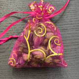 Divine Sansar- a small, pink organza gift pouch filled with dried rose buds.