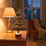 Geniune Pyrite Stone Tree of Life on a wooden table with a lamp and chair in a cozy room.