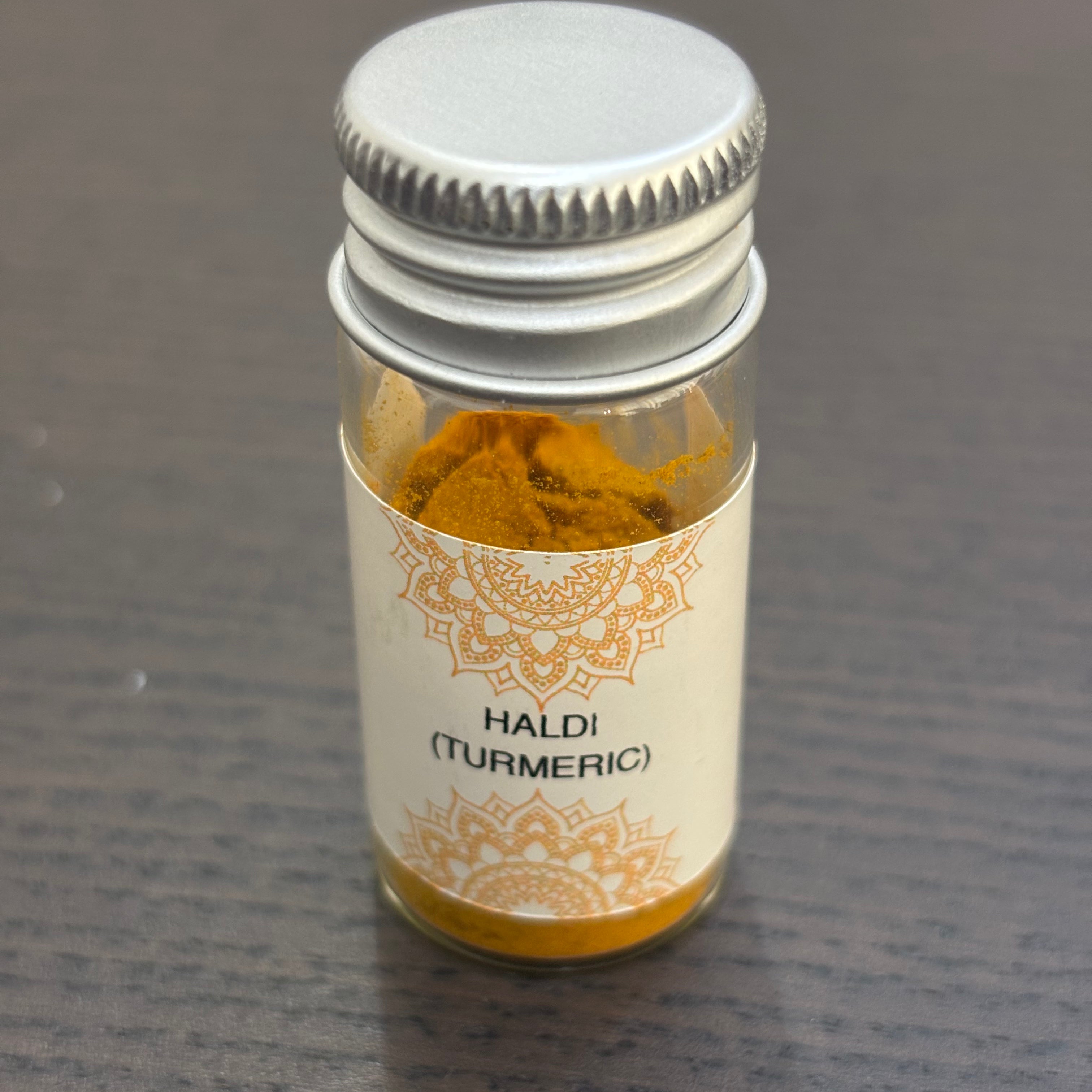 Divine Sansar Haldi Powder (Turmeric) bottle on a dark surface