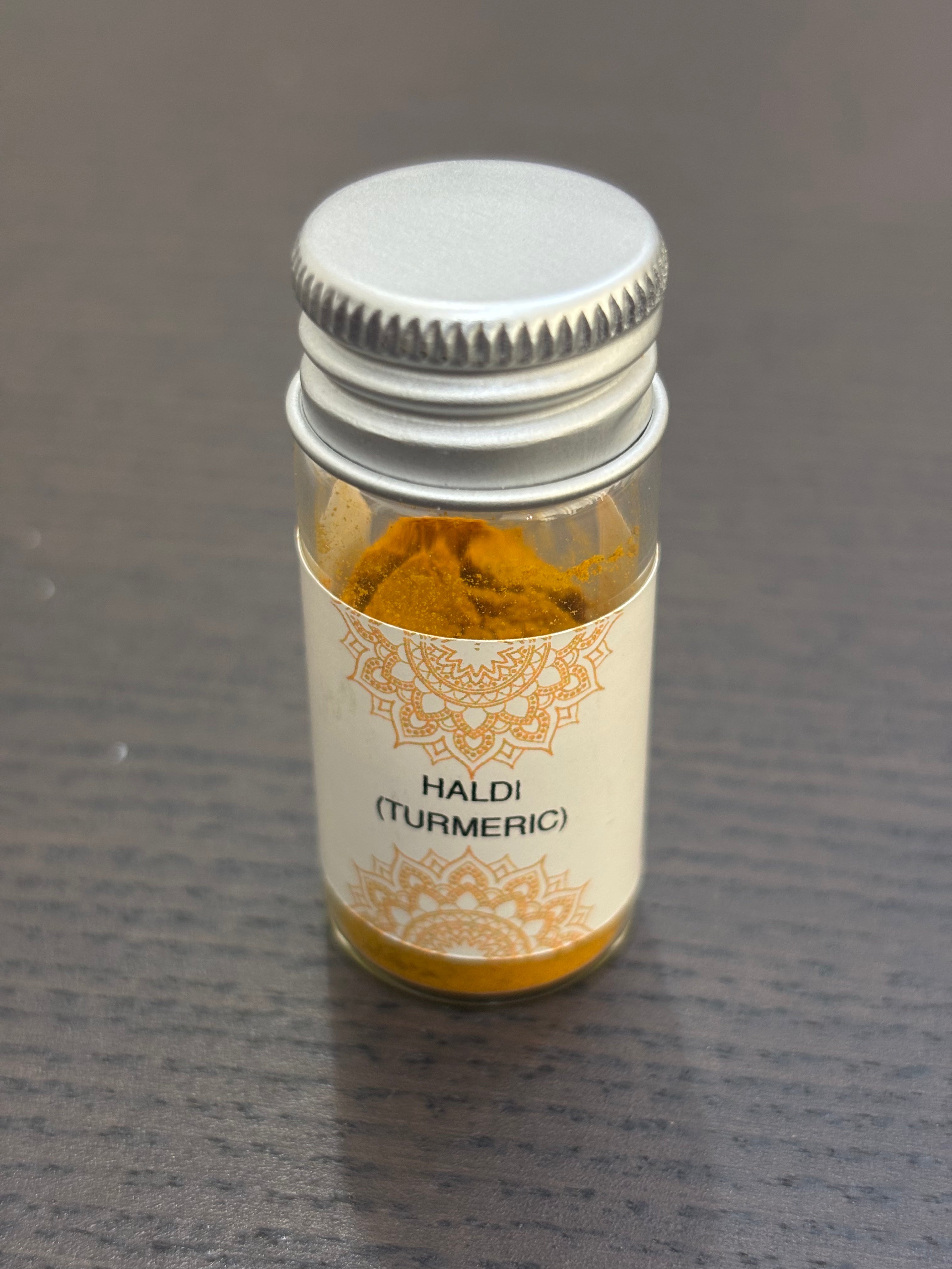 Divine Sansar Haldi Powder (Turmeric) bottle on a dark surface