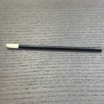 Divine Sansar-Black makeup brush with white bristle tip on a gray textured surface