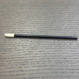 Divine Sansar-Black makeup brush with white bristle tip on a gray textured surface