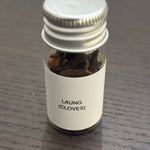Divine Sansar Laung (cloves) bottle with a metal cap on a wooden surface.