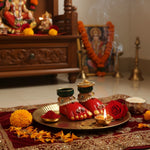 Laxmi Charan pair on a brass thali at a home mandir with a lit diya, marigold, rose and kumkum for Lakshmi Pujan, Divine Sansar
