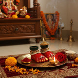 Laxmi Charan pair on a brass thali at a home mandir with a lit diya, marigold, rose and kumkum for Lakshmi Pujan, Divine Sansar