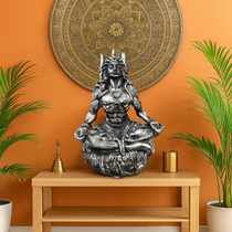 Divine Sansar Antique Meditating Shiva Statue on a wooden shelf with plants and a mandala wall art in the background.