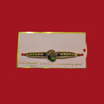 Divine Sansar-Meenakari Peacock Rakhi Design 1, on a card with 'Mohan' branding against a red background