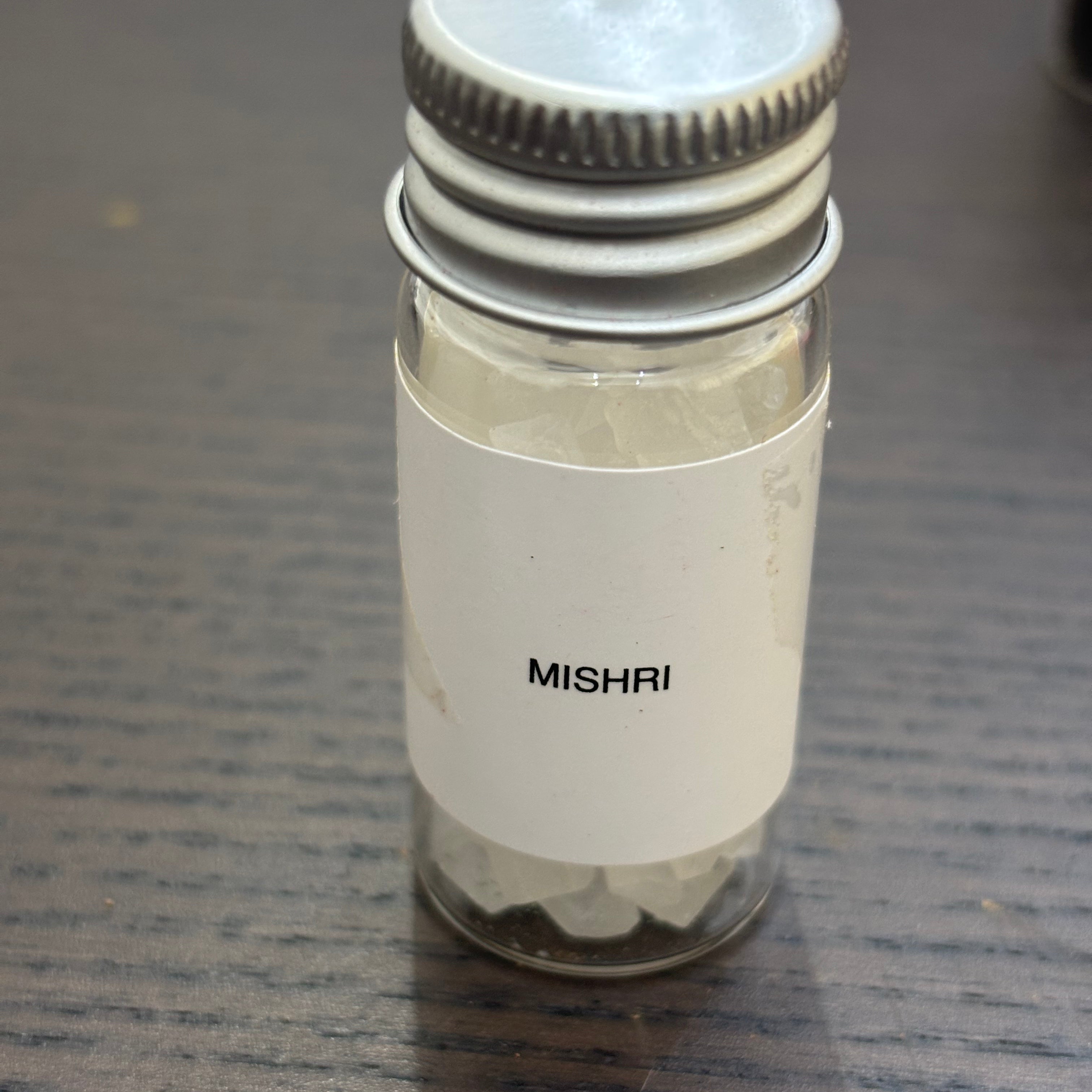 Divine Sansar-Mishri (Rock Sugar) bottle for pooja purpose on a dark surface
