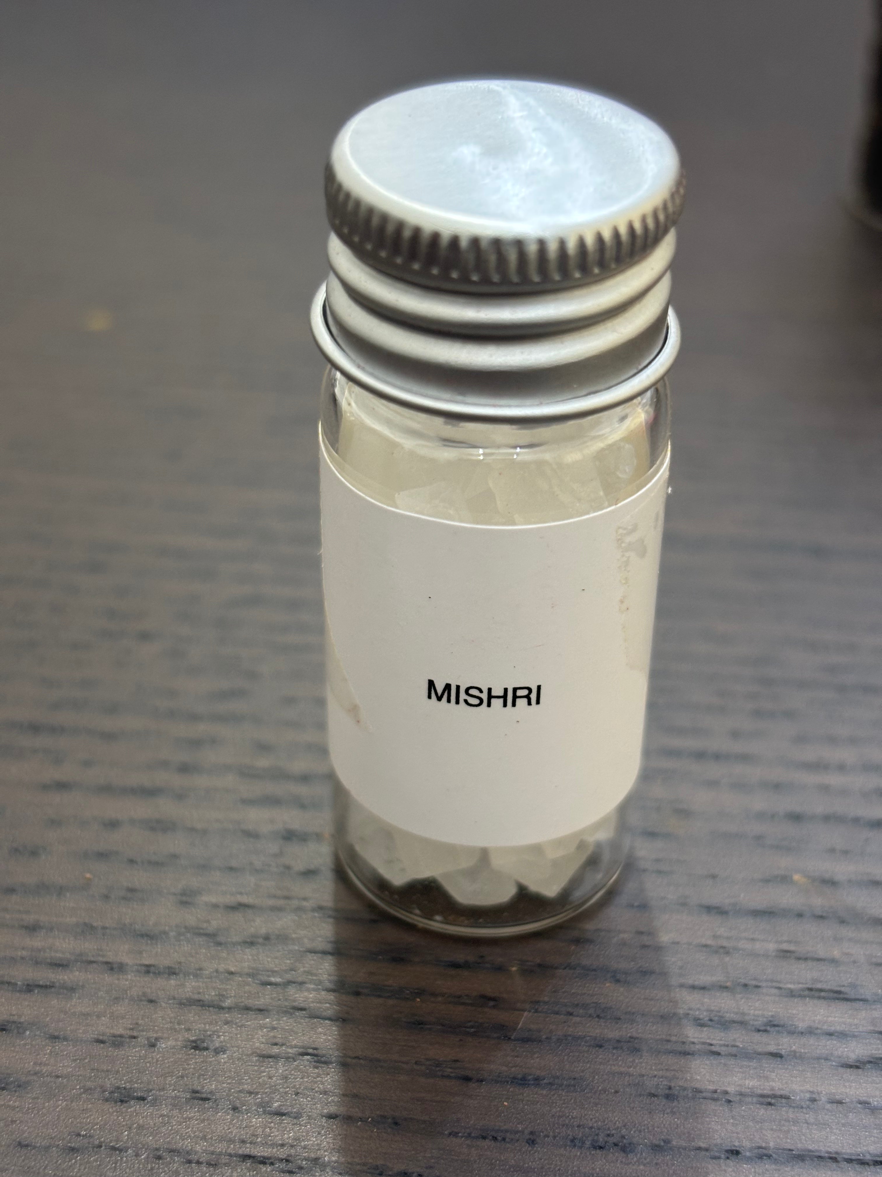 Divine Sansar-Mishri (Rock Sugar) bottle for pooja purpose on a dark surface