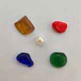 Divine Sansar-Five colored stones on a light gray background