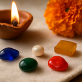 Divine Sansar-Panchratna Set – 5 Sacred Gems in a Diwali-themed setup with a lit oil lamp, marigold flower, on a textured surface.