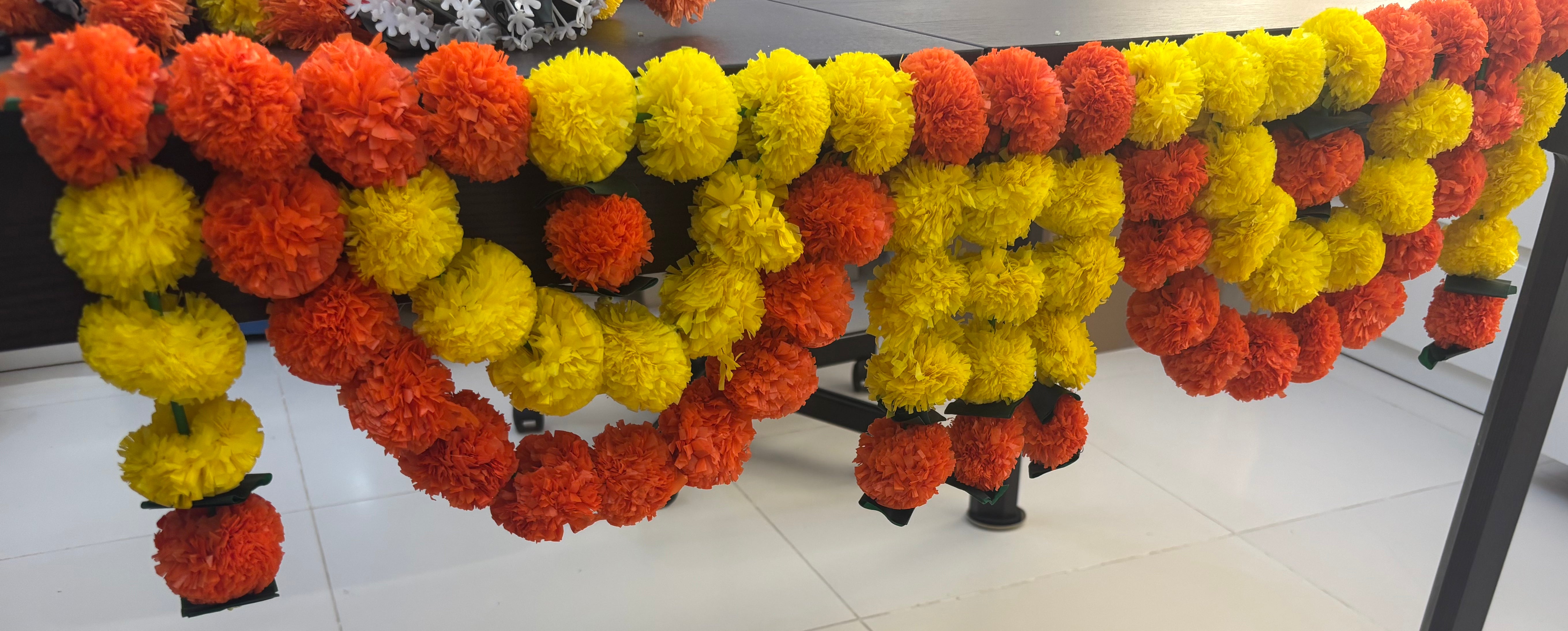 Divine Sansar-Premium Artificial Marigold Toran: Lemon & Orange Flower Strings-hanging in decorative swags. 
