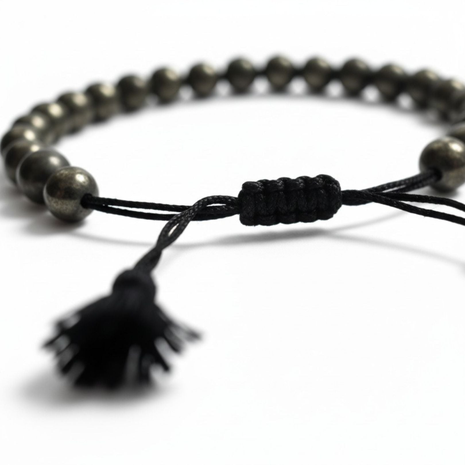 Close-up of the braided pyrite bracelet sliding knot and black tassel - Divine Sansar