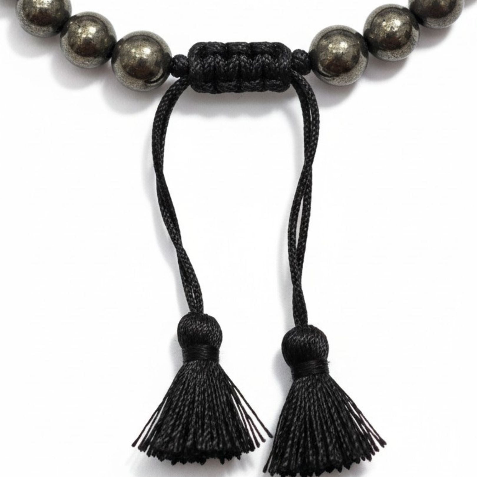 Macro of the black macrame sliding knot and twin tassels on the Braided Fit pyrite bracelet - Divine Sansar