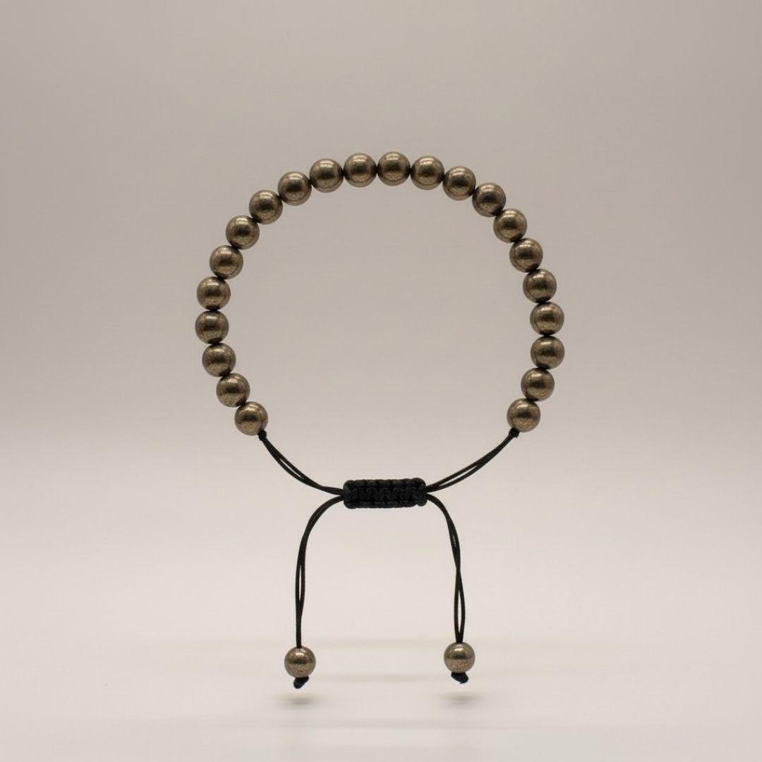 Divine Sansar Pyrite Braided front- Beaded bracelet with black cord on a light gray background