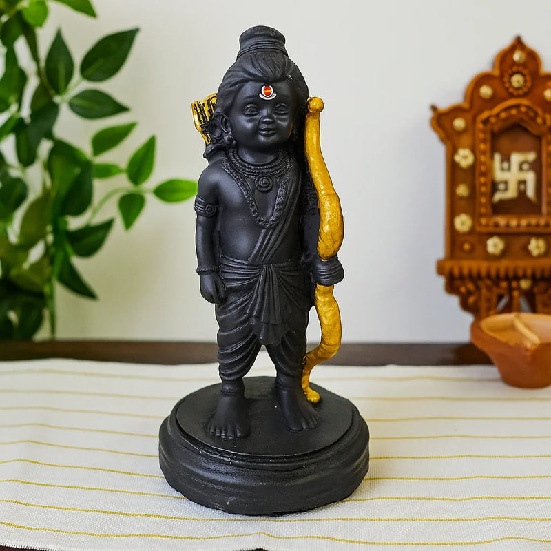 Divine Sansar Divine Ram Lala Statue on a white surface with a plant and wooden object in the background.