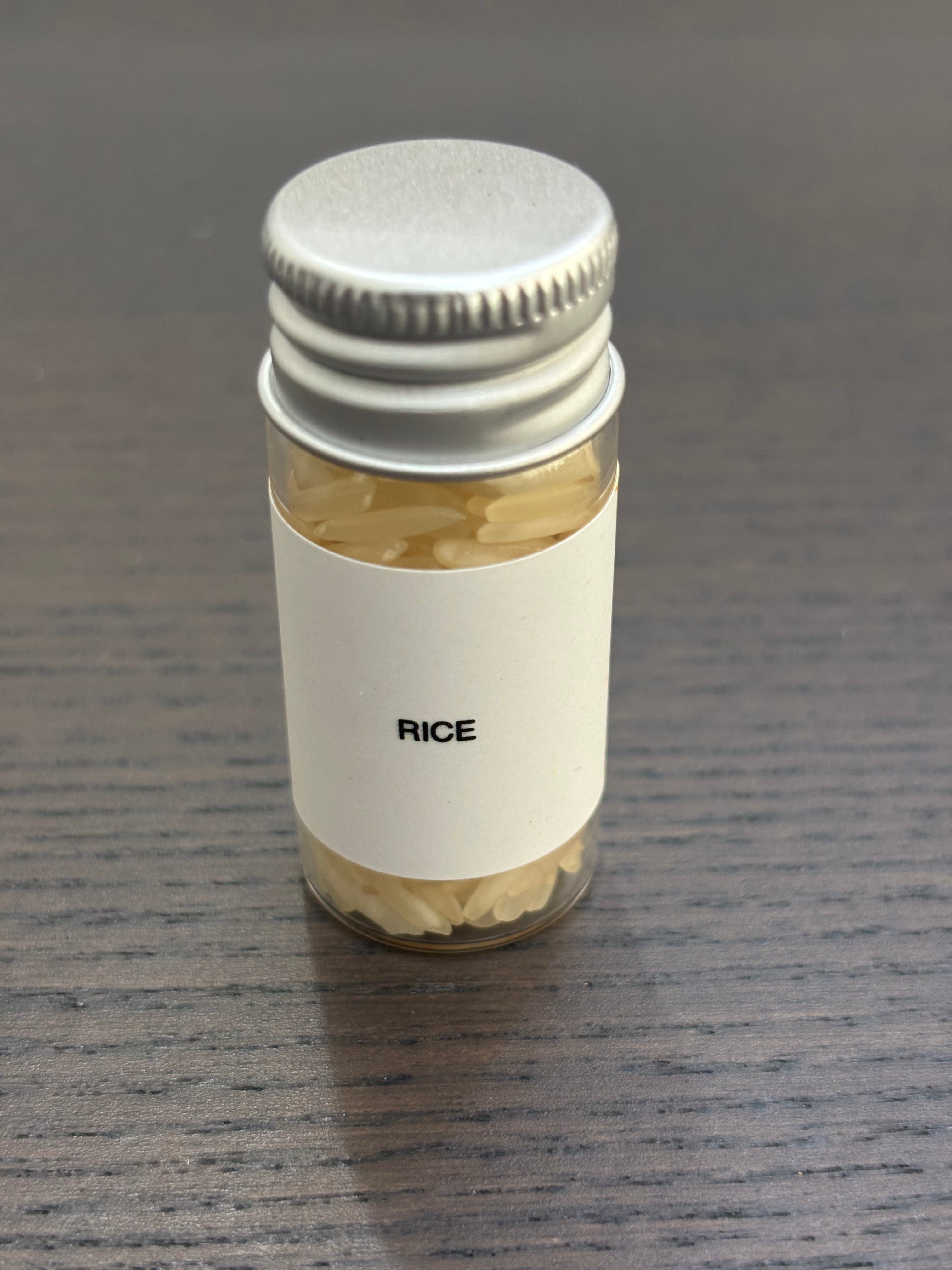 Divine Sansar Rice bottle with a metal lid on a dark surface