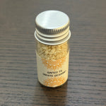 Divine Sansar Safed Til-Small jar of white sesame seeds with a decorative label on a wooden surface