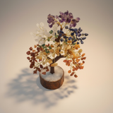 Seven Chakra Crystal Tree of Life self-charging with multicolored stones on a neutral background