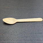 Divine Sansar-Wooden spoon on a dark textured surface
