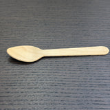 Divine Sansar-Wooden spoon on a dark textured surface
