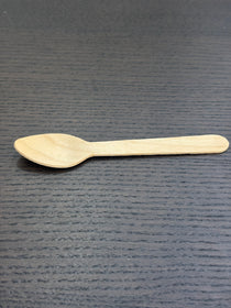 Divine Sansar-Wooden spoon on a dark textured surface