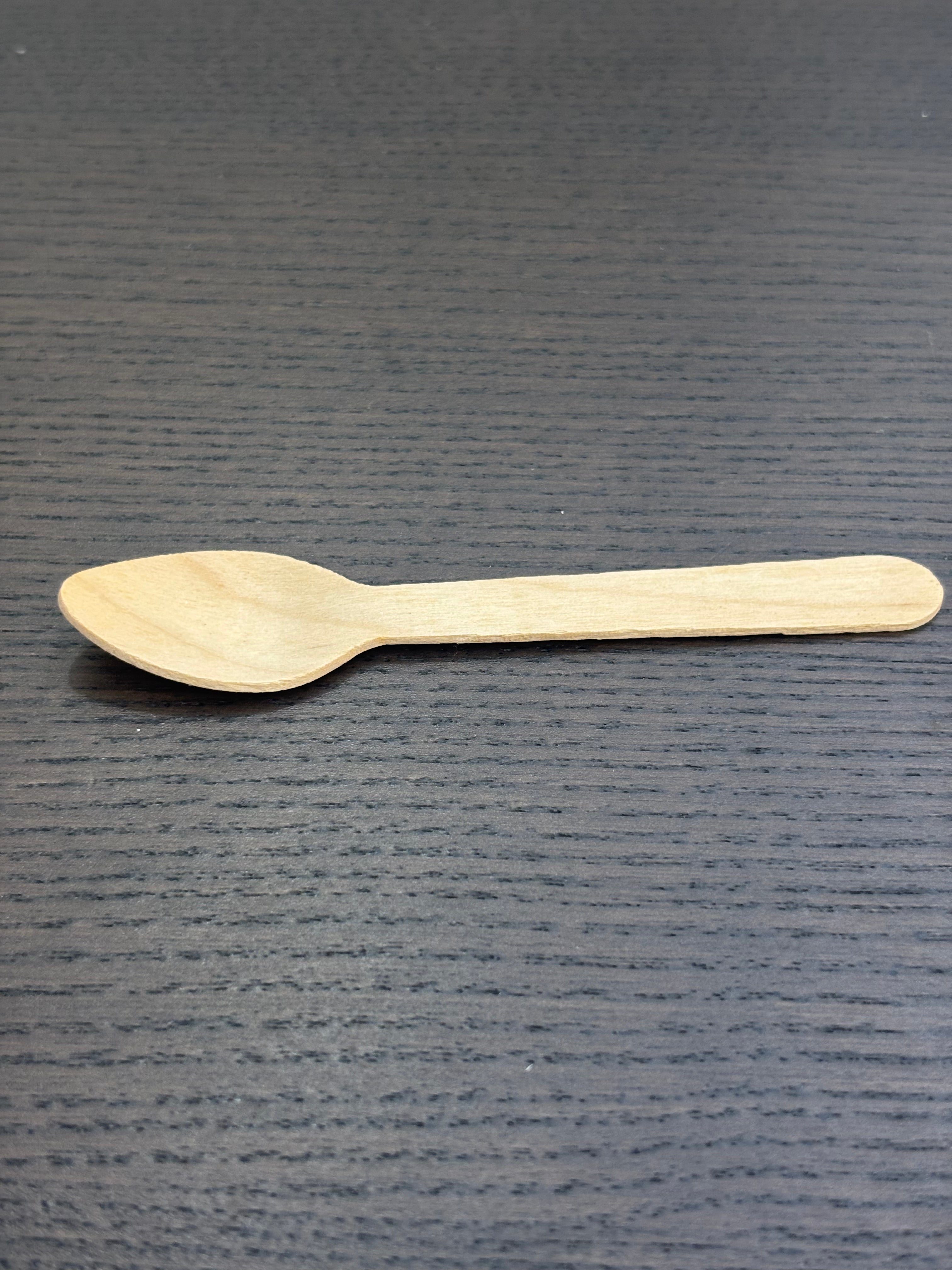 Divine Sansar-Wooden spoon on a dark textured surface