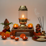 Brass akhand jyot lantern lit on a pooja chowki with kalash and Lakshmi idol - Divine Sansar