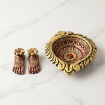 Big clay diya with Laxmi Charan pair, hand-painted gold peacock diya and copper charan on white marble - Divine Sansar