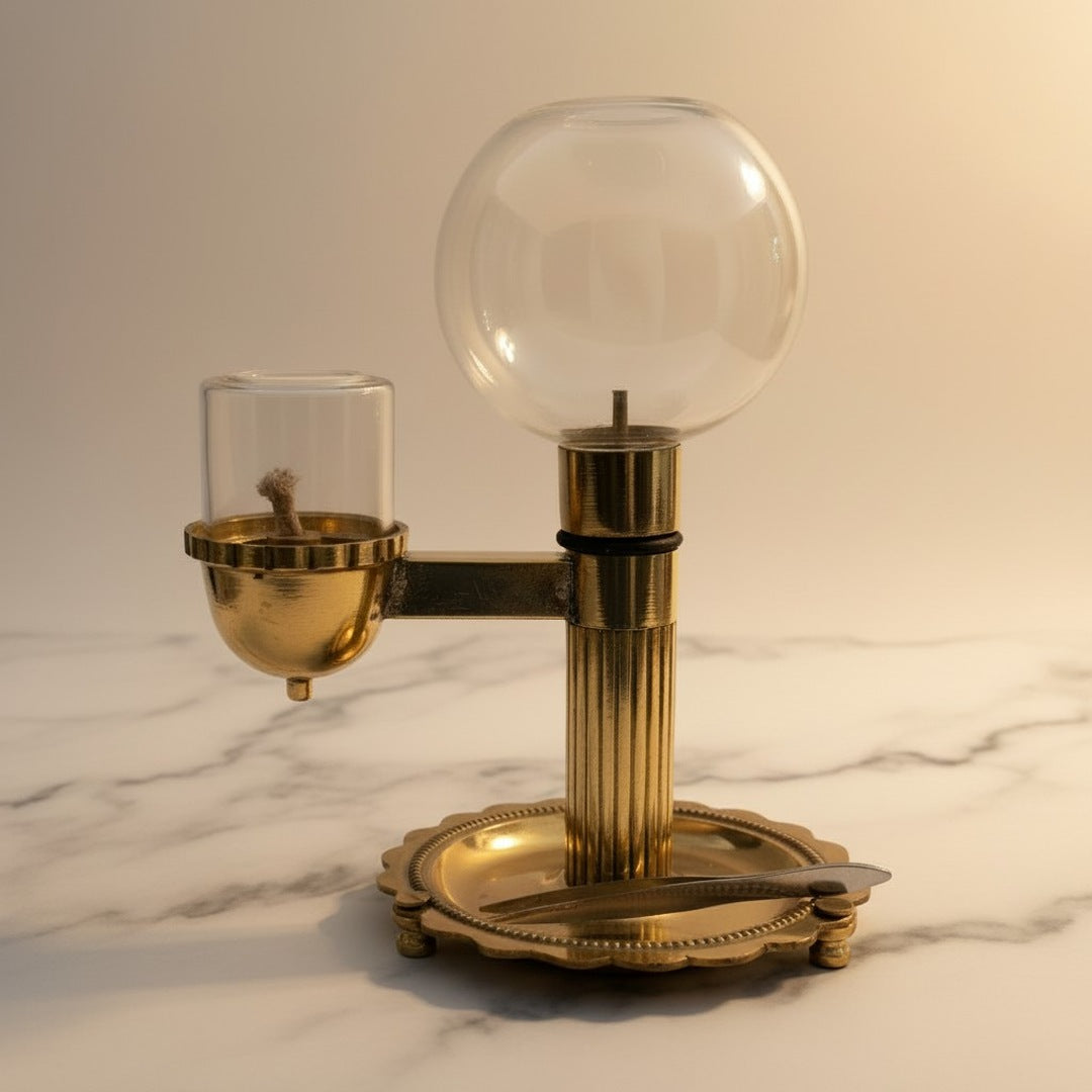 Brass akhand diya with glass globe oil reservoir on white marble - Divine Sansar