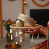 Mehndi hands holding the Classic Elegance orange and gold Karwa Chauth thali with zari lace chhalni - Divine Sansar