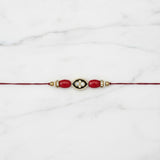 Coral meenakari moonga rakhi on marble - Divine Sansar