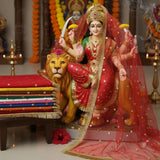 Red net mata ki chunni draped on a Durga idol in a home mandir with the folded set of 10 beside it - Divine Sansar