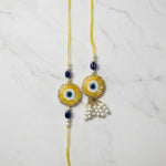 Golden evil eye nazar rakhi lumba set on marble - Divine Sansar