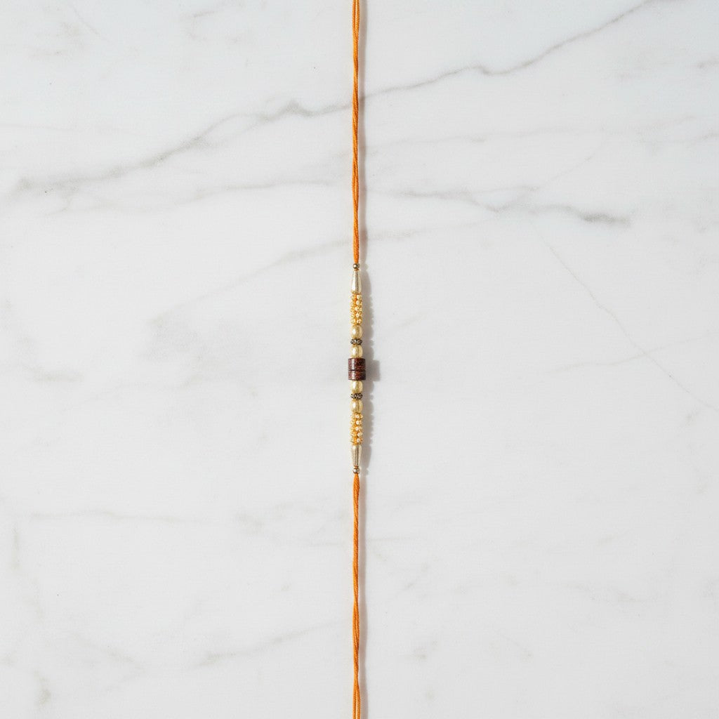 Mangal Moti Pearl and Red Stone Rakhi on marble - Divine Sansar UAE