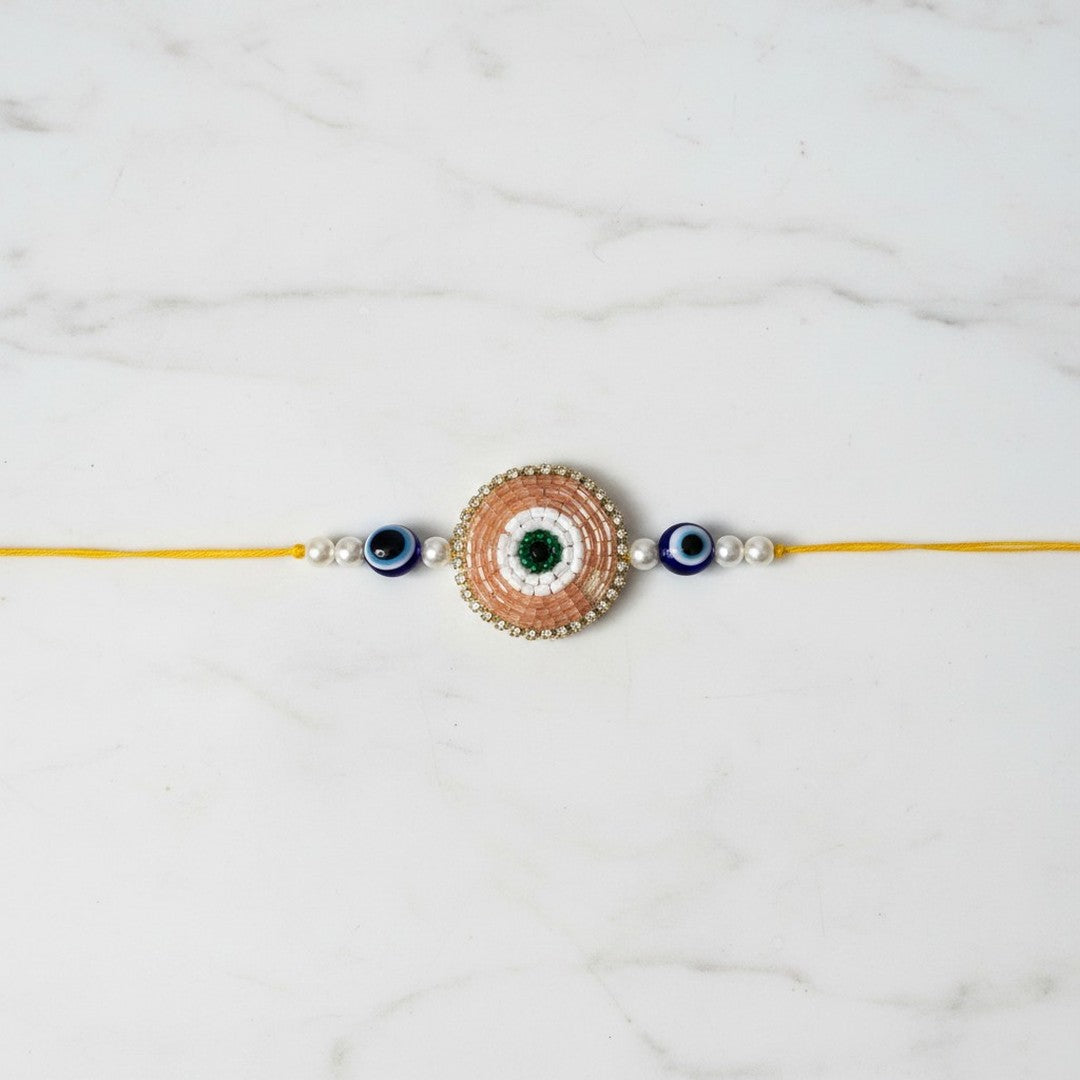 Peach beaded evil eye nazar rakhi on marble - Divine Sansar