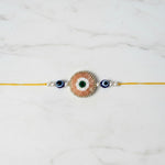 Peach beaded evil eye nazar rakhi on marble - Divine Sansar