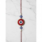 Red beaded evil eye nazar rakhi on marble - Divine Sansar