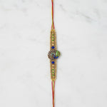 Mayura Tejas Gold Peacock Meenakari Rakhi on marble - Divine Sansar UAE