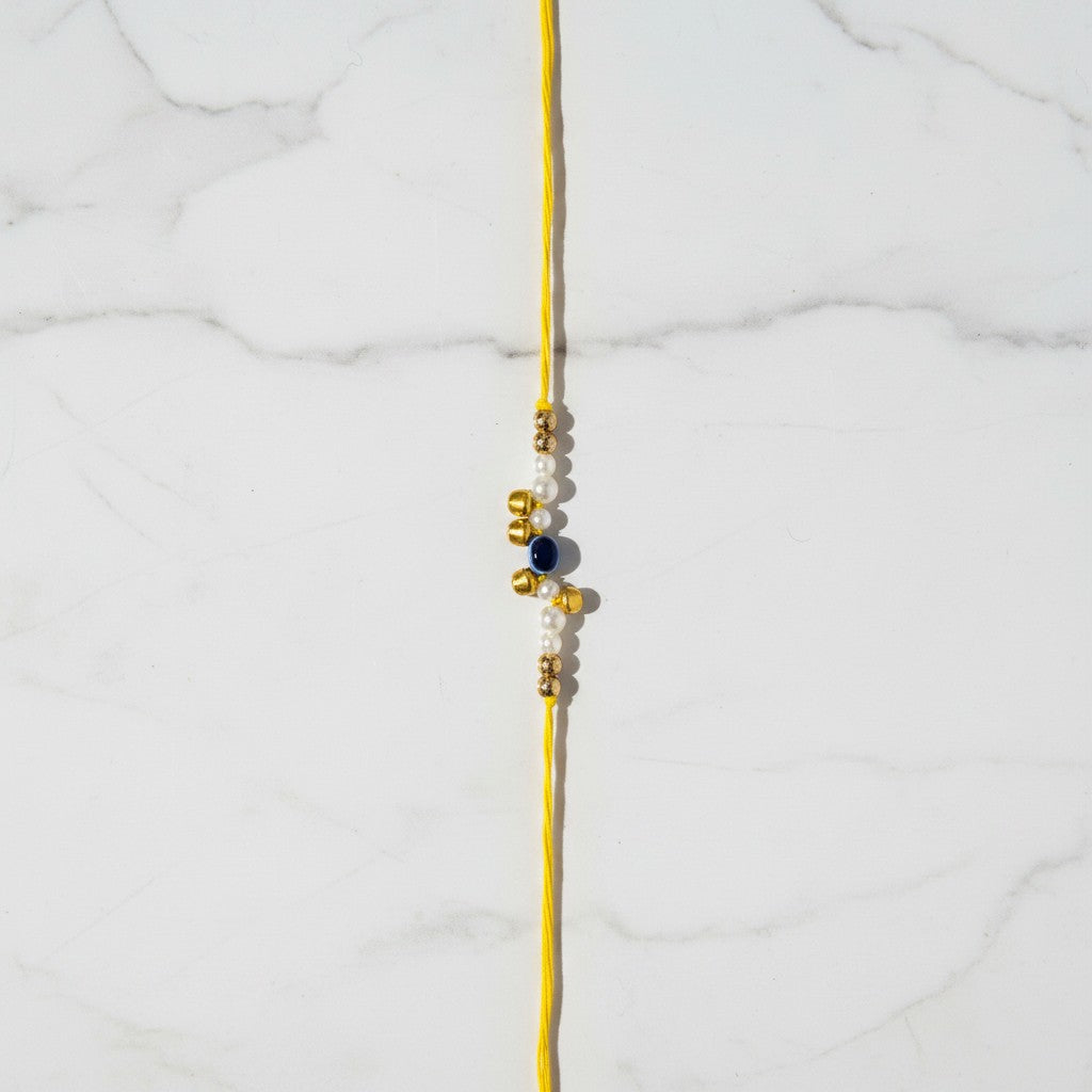 Moti Nazar Pearl Evil Eye Rakhi on marble - Divine Sansar UAE