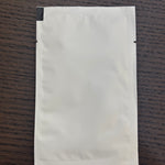 Divine Sansar-White paper pouch on a wooden surface