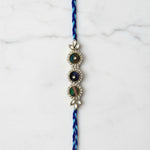Peacock feather Mor Pankh rakhi on marble - Divine Sansar