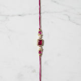 Gulabi Noor Pink Stone Rakhi on marble - Divine Sansar UAE