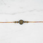Two-sided pyrite prosperity rakhi on marble - Divine Sansar
