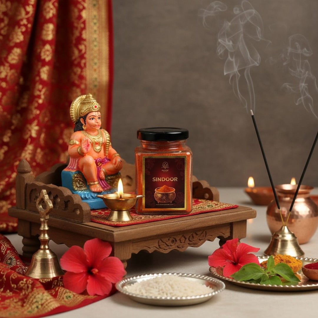 Hanuman Sindoor 100gm jar on a pooja chowki beside a Hanuman Ji murti and diya - Divine Sansar