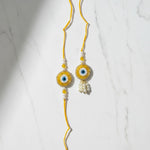 Drishti Jodi Sunehri Golden Evil Eye Bhaiya Bhabhi Rakhi Set on marble - Divine Sansar UAE