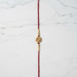 Swarna Mor Gold Peacock Rakhi on marble - Divine Sansar UAE
