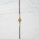 Swarna Mor Gold Peacock Rakhi on marble - Divine Sansar UAE