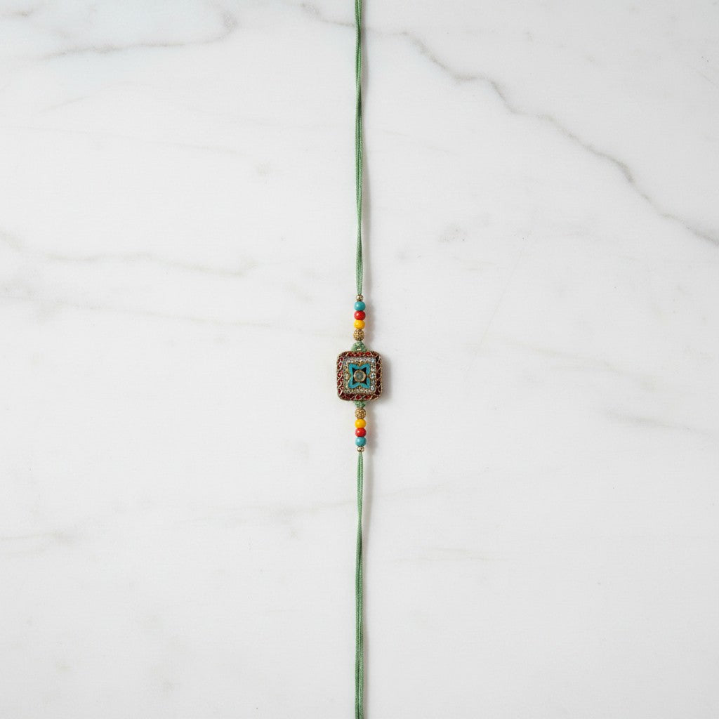 Vanasri Green Meenakari Rakhi on marble - Divine Sansar UAE