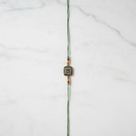 Vanasri Green Meenakari Rakhi on marble - Divine Sansar UAE